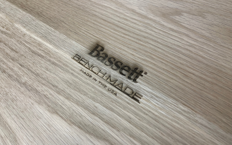 The Bassett BenchMade logo is seen stamped into the bottom of a table.