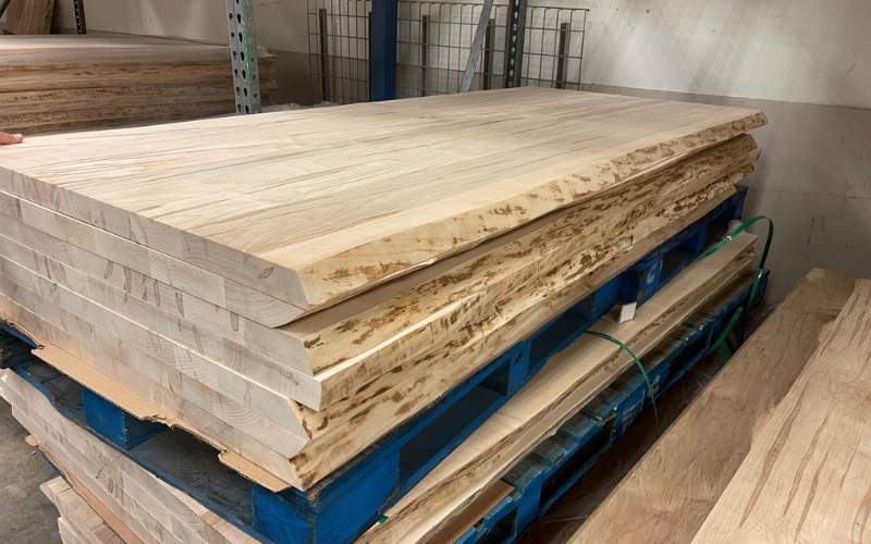 Slabs of solid live edge maple are seen stacked up at the Bassett, Va. BenchMade plant. These will be used as dining table tops.