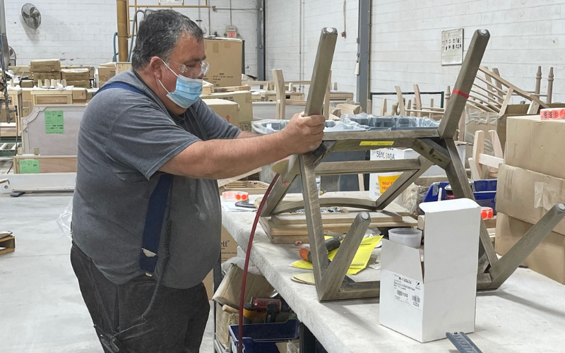 Another worker in the Martinsville plant is seen sanding a chair frame.